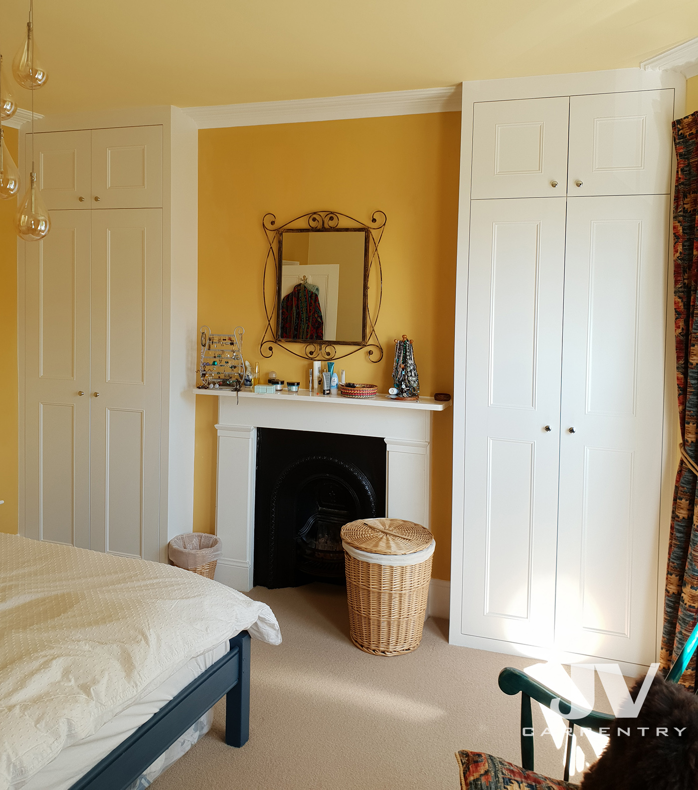 Alcove wardrobes either side of the chimney breast with top cupboard doors