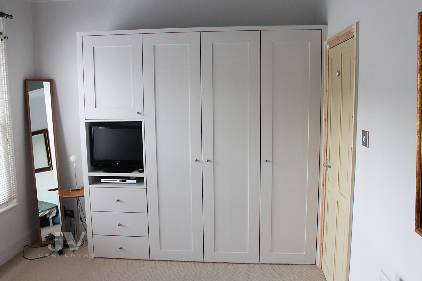 Small built-in wardrobe in the corner of the bedroom by the door. Painted slightly offwite colour