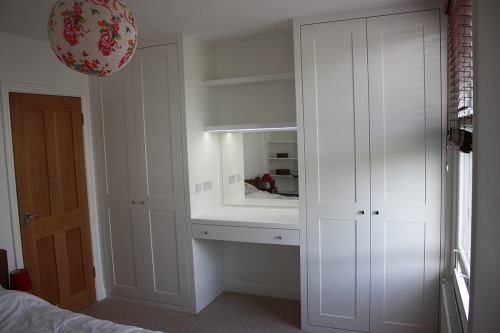 dressing table and floating shelves between two wardrobes